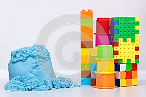 Kids education toys and kinetic sand on the white background. Copy space