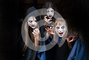 Kids with face-paint and Halloween costumes on a black background