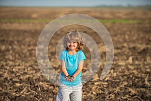 Kids farmer. American child on farm. Soil and ground concept. Textured fertile soil as background. Gardening season.