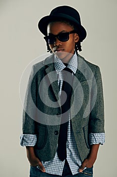 Kids, fashion and boy child with suit in studio for stylish, cool or trendy outfit choice on grey background. Children