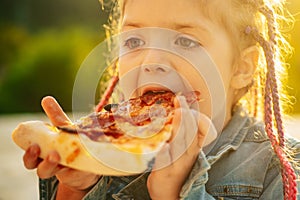 Kids favorite food. Tasty pizza. Child eating pizza. Fastfood. Italian junkfood. Little girl lunch outdoor.