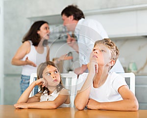 Kids feels upset while parents quarrel at background. Little girl and boy frustrated with psychological problem caused