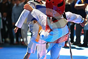 Kids fighting on stage during Taekwondo contest