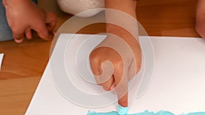 Kids finger painting on sheets of paper