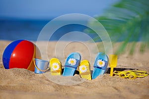 Kids flip-flops, beach ball and snorkel on the sand. Summer vacation concept