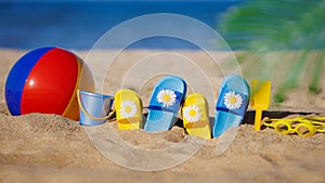 Kids flip-flops, beach ball and snorkel on the sand. Summer vacation concept