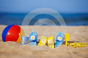 Kids flip-flops, beach ball and snorkel on the sand. Summer vacation concept