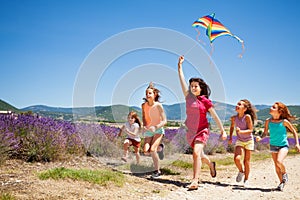 Kids flying kite running through lavender field