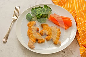 Kids food. nuggets with vegetables. Dinosaur shaped chicken, fish or turkey nuggets, ready to eat