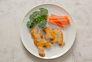 Kids food. nuggets with vegetables. Dinosaur shaped chicken, fish or turkey nuggets, ready to eat