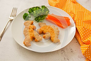 Kids food. nuggets with vegetables. Dinosaur shaped chicken, fish or turkey nuggets, ready to eat