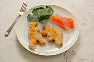 Kids food. nuggets with vegetables. Dinosaur shaped chicken, fish or turkey nuggets, ready to eat