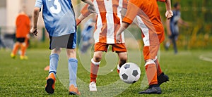 Kids Football Players Kicking Ball on Soccer Field. Youth Junior Athletes in Red and Blue Soccer Shirts