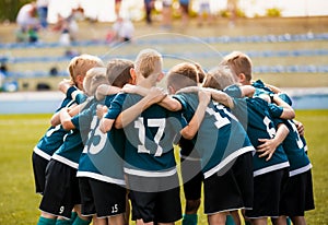 Kids football team building team spirit. Soccer children team in huddle