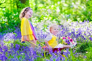 Kids in a garden with bluebell flowers