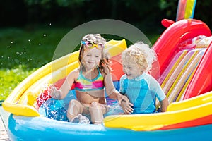 Kids in garden swimming pool with slide