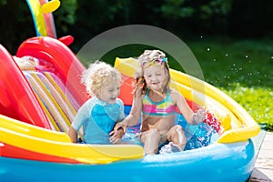 Kids in garden swimming pool with slide