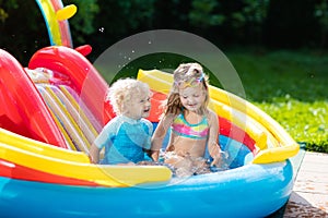 Kids in garden swimming pool with slide