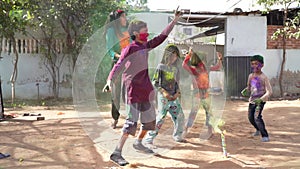 Kids gathering together celebrating a Holi party in the outdoor with happiness expressions and covered with vivid holi colors