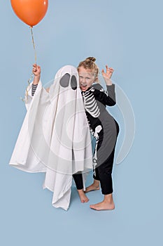 Kids in a ghost and skeleton costumes at Halloween have fun at studio