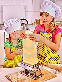 Kids girl making homemade pasta at kitchen