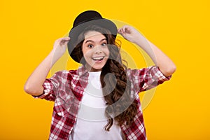 Kids girl in old fashion clothes. Elegent hat, cylinder hat isolated on yellow background. Headwear. Clothes accessories