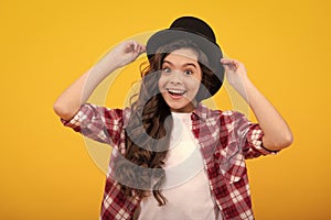 Kids girl in old fashion clothes. Elegent hat, cylinder hat isolated on yellow background. Headwear. Clothes accessories