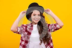 Kids girl in old fashion clothes. Elegent hat, cylinder hat  on yellow background. Headwear. Clothes accessories