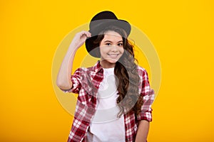 Kids girl in old fashion clothes. Elegent hat, cylinder hat isolated on yellow background. Headwear. Clothes accessories photo