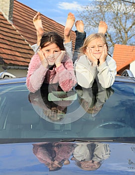 Kids - girls on windscreen of a car photo