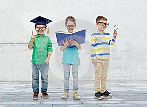 Kids in glasses with book, lens and bachelor hat