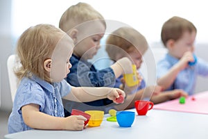 Kids group learning arts and crafts in playroom with interest