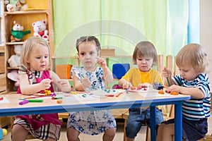 Kids group making arts and crafts in kindergarten.