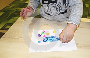 Kids group making arts and crafts in kindergarten. Children spending time in day care centre with the great interest