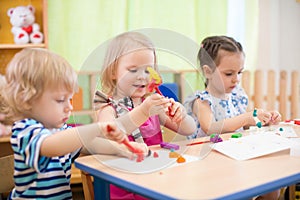 Kids group making arts and crafts in kindergarten with interest