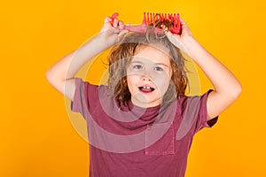 Kids hair. Child combing hair after shower. Cute child with comb. Blonde kid combs unruly hair. Kid boy with tangled