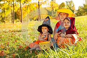 Kids in Halloween costumes sitting on the grass