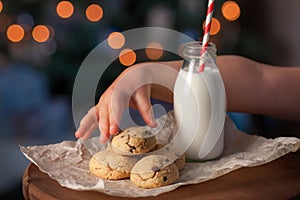 Kids hand taking a cookie prepared for Santa Claus