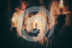 Kids are handling candles in the traditionall dresses. Celebration of Lucia day in Sweden photo