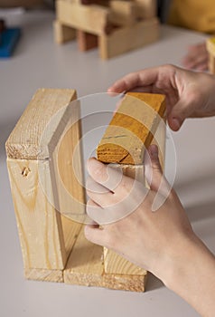 kids hands doing construction, wooden bricks puzzle