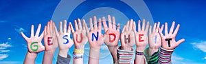 Kids Hands Holding Word Gesundheit Means Health, Blue Sky photo