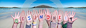 Kids Hands Holding Word Gesundheit Means Health, Ocean Background photo