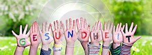 Kids Hands Holding Word Gesundheit Means Health, Grass Meadow photo