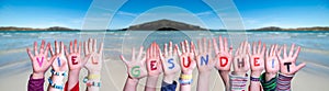 Kids Hands Holding Word Viel Gesundheit Means Stay Healthy, Ocean Background