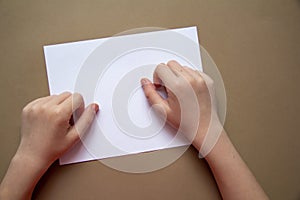 Kids hands with nevus or birthmark are on white list of paper craft paper background