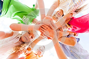 Kids hands together in circle laying one on another