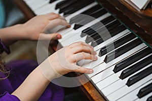 Kids hands on a white piano key