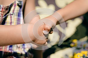 Kids handshake closeup on sunny outdoors background