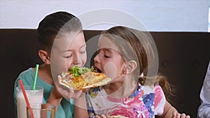 Kids having fun eating pizza in a cafe