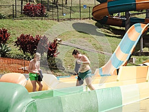 Kids having fun riding water slides on summer vacation